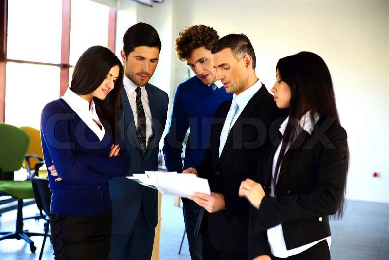 Business people reading a document together in the office, stock photo