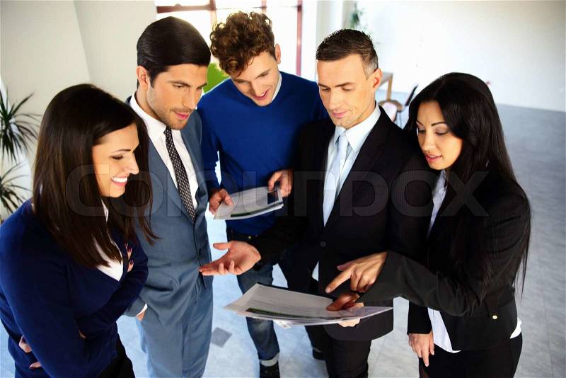 Happy business people looking on the document together, stock photo