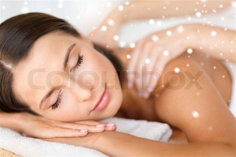 Beauty, health, holidays, people and spa concept - beautiful young woman in spa salon getting massage, stock photo