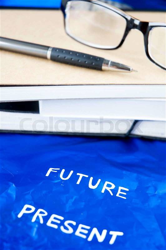 Present and future wording with books background, stock photo