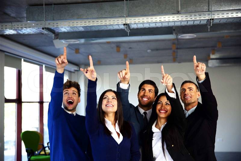 Group of cheerful business people pointing up, stock photo