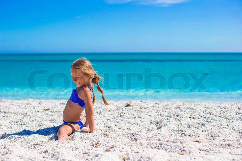 Adorable little sporty girl on white tropical beach, stock photo