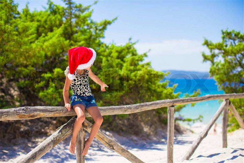Adorable little baby girl in christmas hat during summer vacation, stock photo