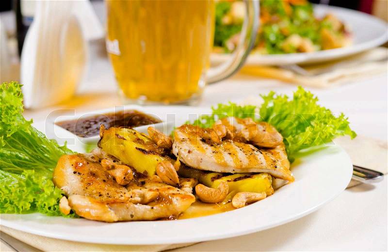 Close Up of Mug of Beer on Restaurant Table with Plated Food, stock photo