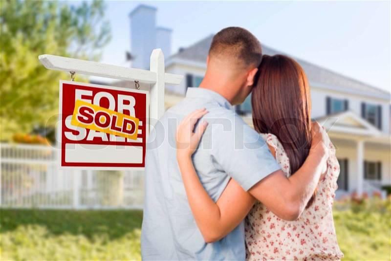 Sold For Sale Real Estate Sign and Affectionate Military Couple Looking at Nice New House, stock photo