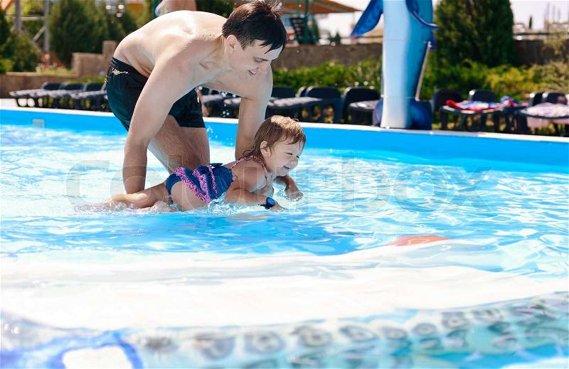 Lessons of swimming from father to daughter, stock photo
