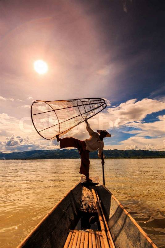Myanmar Inle lake fisherman on boat catching fish by traditional net in village Inlay Shan state of Myanmar, stock photo