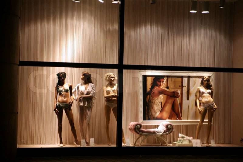 Night time in the street of a city in anvers in belgium, manequin in a shop window, stock photo