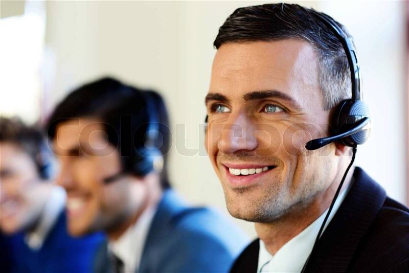Attractive positive young businesspeople and colleagues in a call center office, stock photo