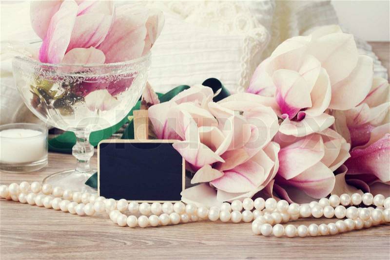 Weding greetings - magnolia flowers, wedding dress and pearls with copy space on black chalk board, stock photo