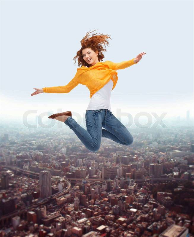 Happiness, freedom, movement and people concept - smiling young woman jumping high in air, stock photo