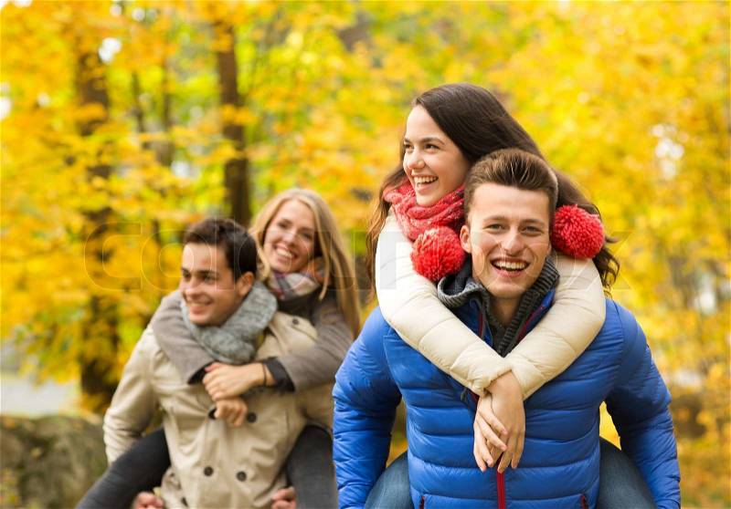 Love, friendship, family and people concept - smiling friends having fun in autumn park, stock photo