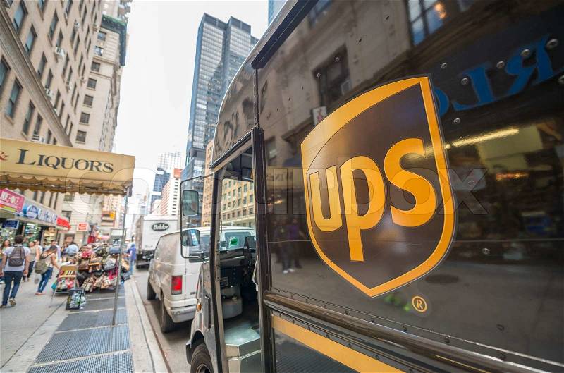 NEW YORK CITY - MAY 13, 2013: The ups-logo on a UPS van in the streets of New York, people walking by in the reflection of the van, stock photo