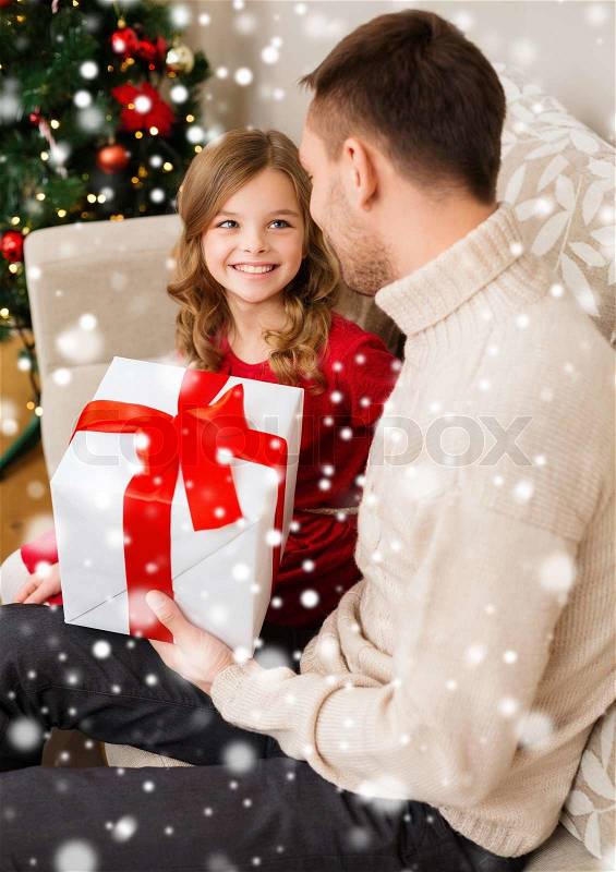Family, christmas, winter holidays, childhood and people concept - smiling father and daughter holding gift box at home, stock photo
