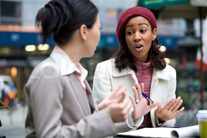 Two business women having a casual meeting or discussion in the city. , stock photo