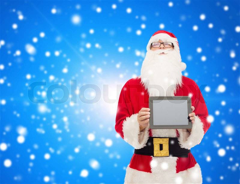 Christmas, advertisement, technology, and people concept - man in costume of santa claus with tablet pc computer over blue snowy background, stock photo