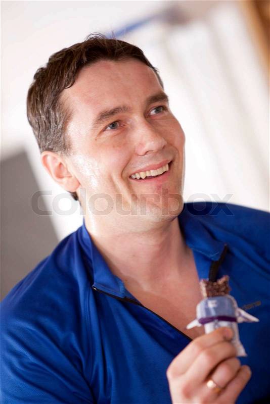 A male caucasian athlete eating an energy bar, stock photo