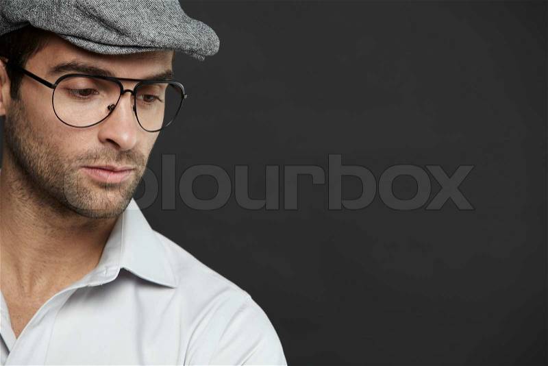 Mid adult man wearing glasses and hat, studio shot, stock photo