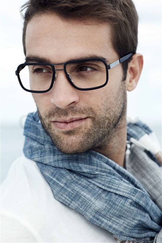 Mid adult man wearing scarf and spectacles on beach, stock photo