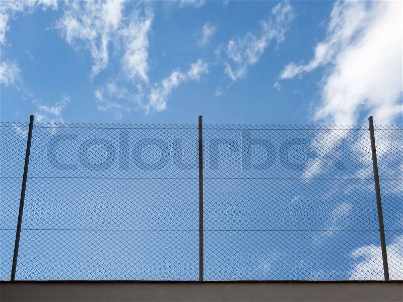 Metal Rabitz mesh fence against blue sky background, stock photo