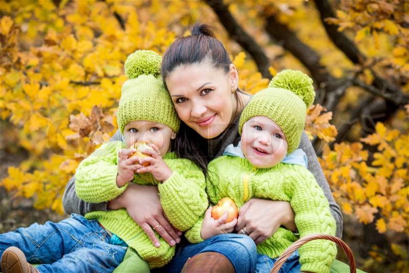 Two little brother and mother on walk in the autumn forest, stock photo