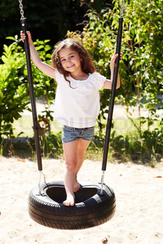 Young girl on tire swing, portrait, stock photo