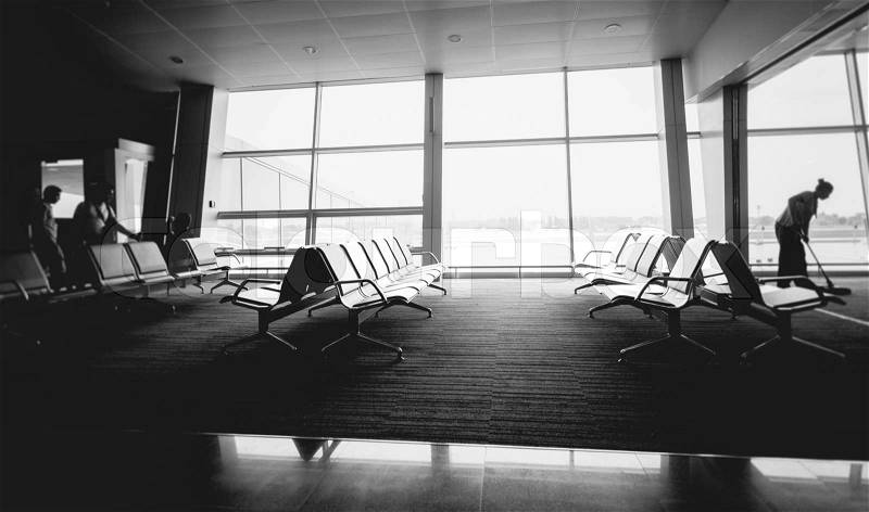 Black and white photo of rows of seats at airport terminal, stock photo