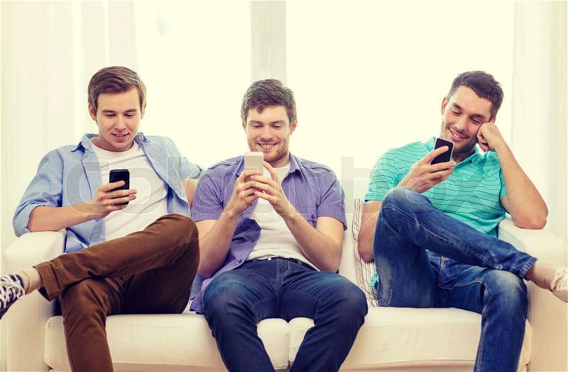 Friendship, technology and home concept - smiling male friends with smartphones at home, stock photo