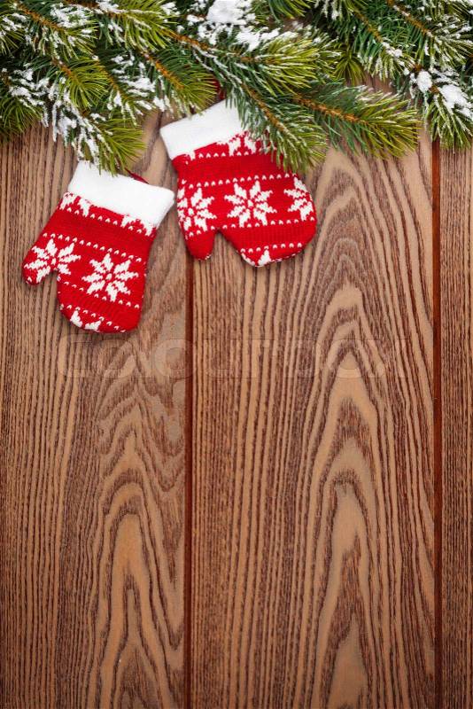 Christmas mitten decor and snow fir tree over wooden background with copy space, stock photo