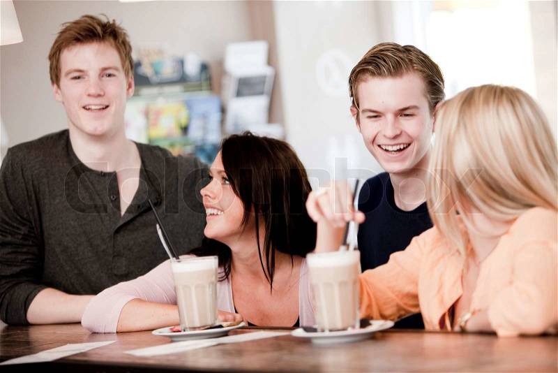 Two young caucasian couples on a double date drinking cafe latte, stock photo