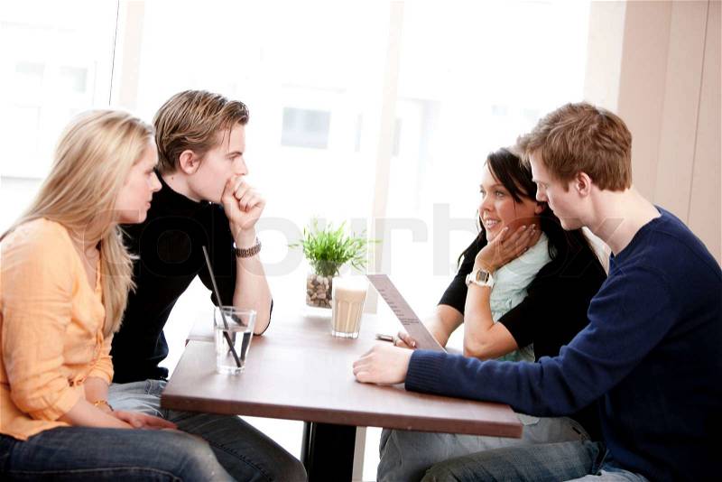 Two young caucasian couples on a double date in a restaurant/cafe, stock photo