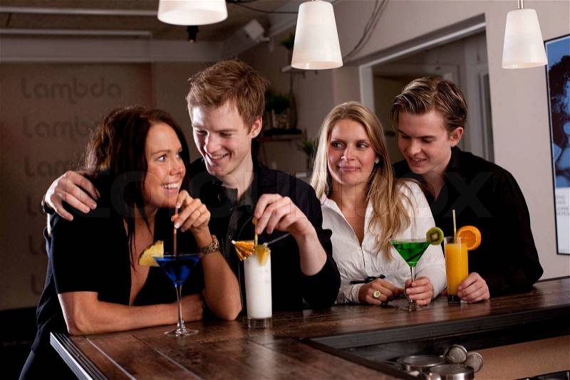 A group of young Europeans enjoying drinks in a bar, stock photo