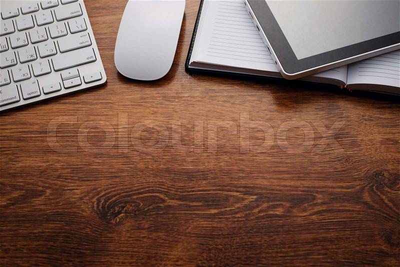 Close up Clean Open Notebook and Electronic Devices such as Keyboard, Mouse and Tablet, on Top of Wooden Table with Copy Space Below for Texts, stock photo