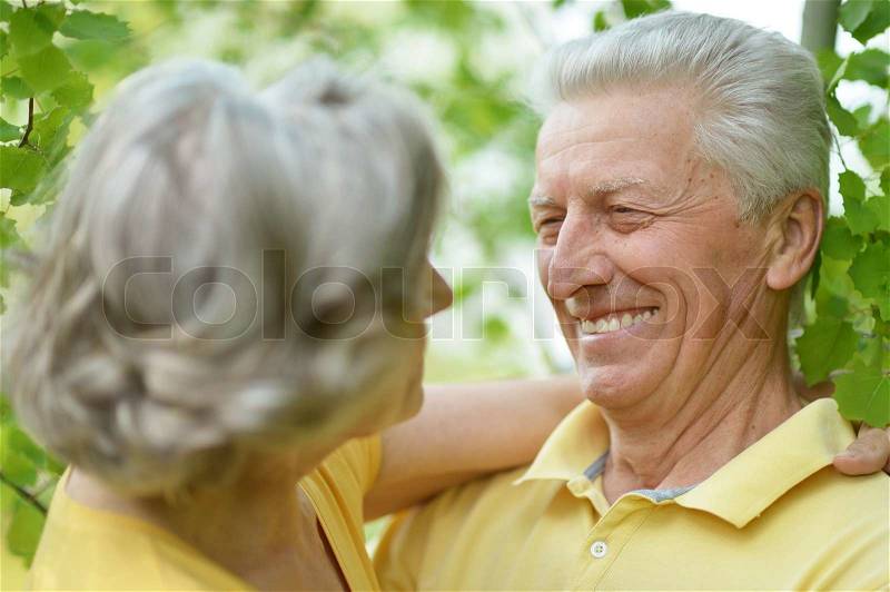 Portrait of beautiful old people embracing outdoors on the walk, stock photo