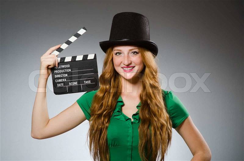 Woman wearing green dress with movie board, stock photo