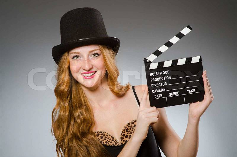 Woman with movie board wearing hat, stock photo