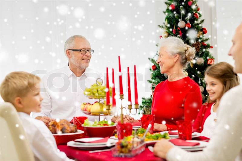 Family, holidays, generation, christmas and people concept - smiling family having dinner at home, stock photo