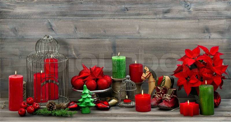 Vintage christmas decorations with red candles, flower poinsettia, stars and baubles. dark designed picture, stock photo