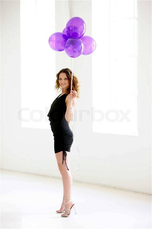 A young caucasian woman holding purple balloons, stock photo
