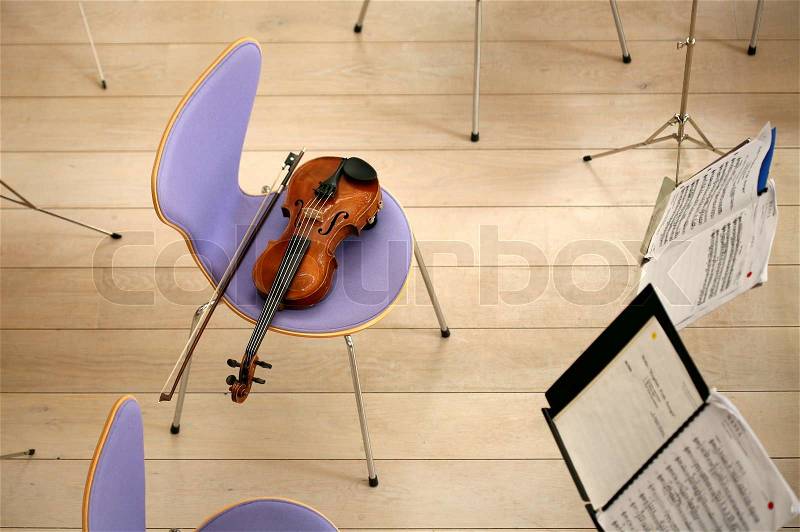 Violin on a chair and opened music note book concert orchester shot while zooming at low shutter speed (no photoshop), stock photo