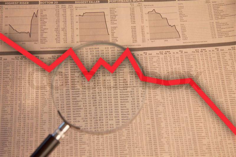 Magnifying glass examine stock market with red business arrow going down, stock photo