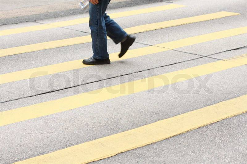 A lone man crossing the pedestrian lane, stock photo