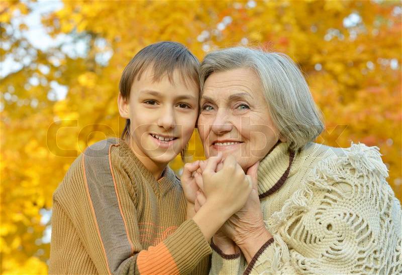 Grandmother with boy in the autumn park, stock photo