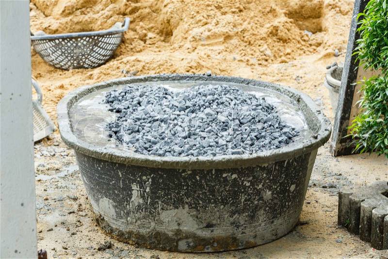 Close up stone and cement in plastic concrete mixing tub , stock photo