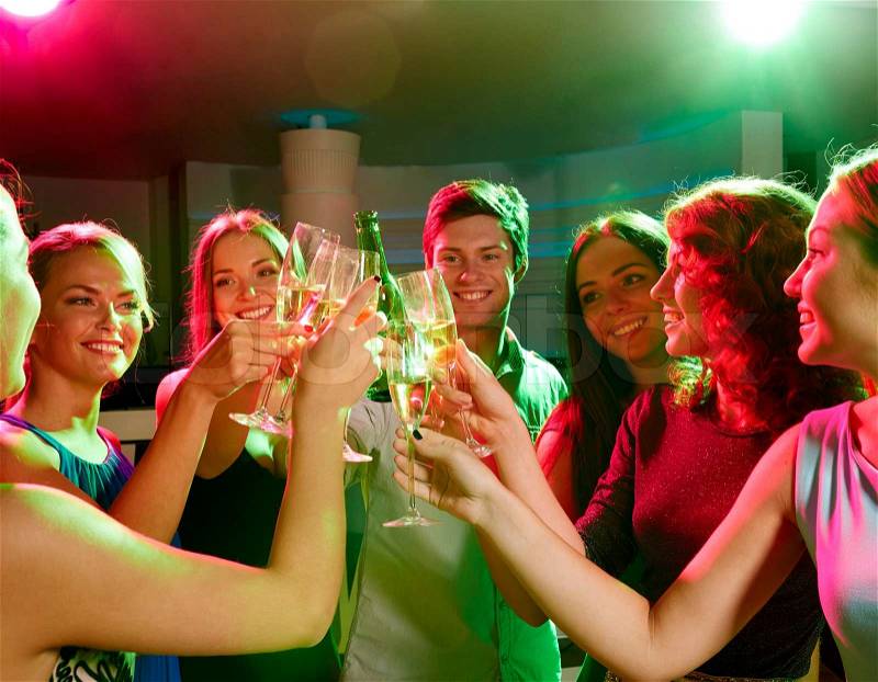 Party, holidays, celebration, nightlife and people concept - smiling friends clinking glasses of champagne and beer in club, stock photo