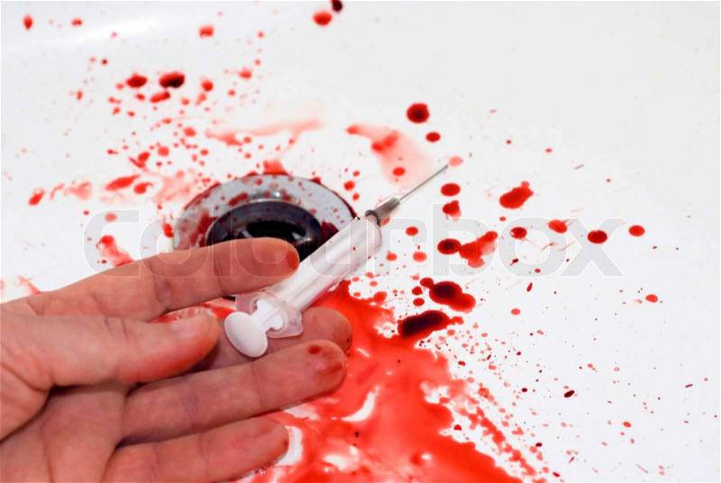 Human hand with a serynge and blood in a bathroom: suicide in a tub, stock photo