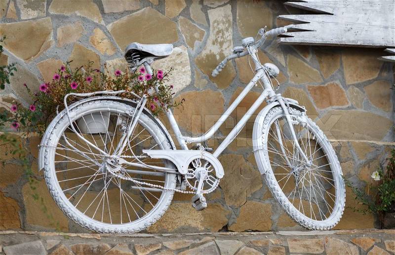Bike, painted with white paint, standing against the wall, stock photo