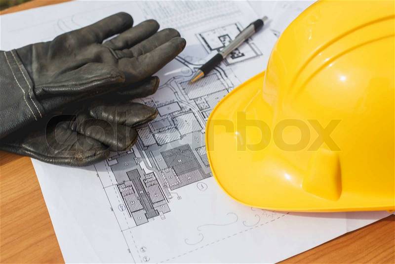 Close up Yellow safety helmet and floor plan drawings on the table, stock photo
