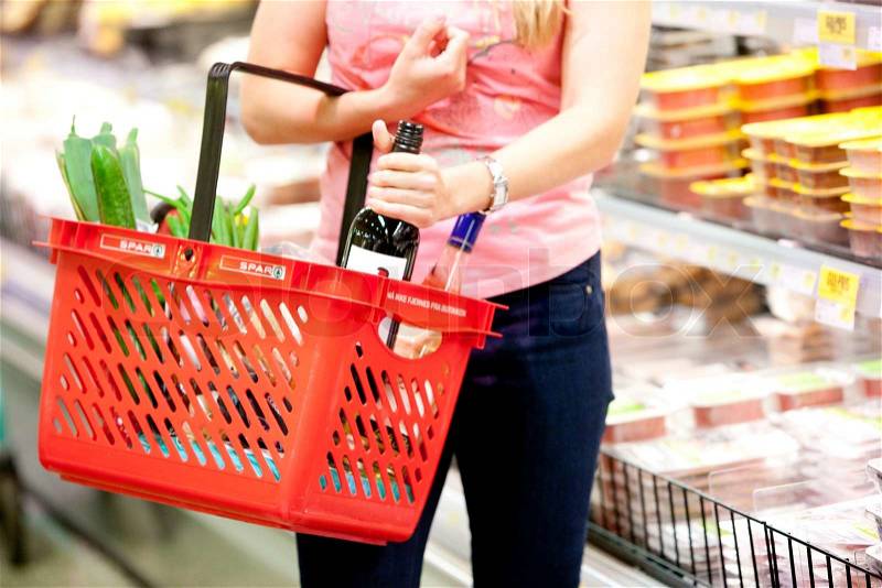 A young blond, caucasian woman in a supermarket buying food, stock photo