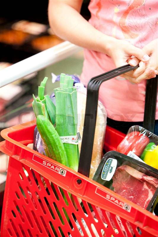 A young blond, caucasian woman in a supermarket buying food, stock photo